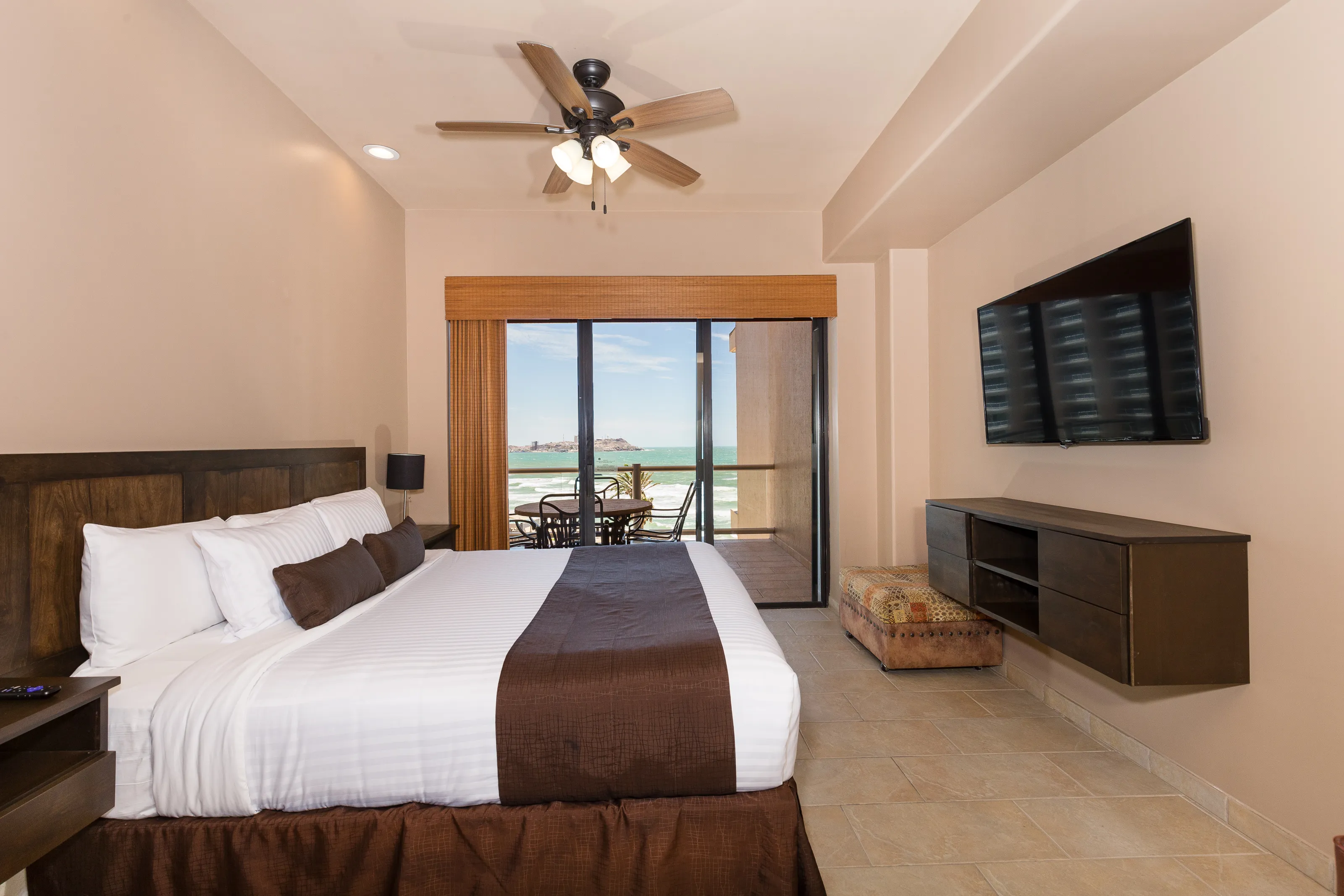 Modern bedroom with a large bed and ocean view balcony.