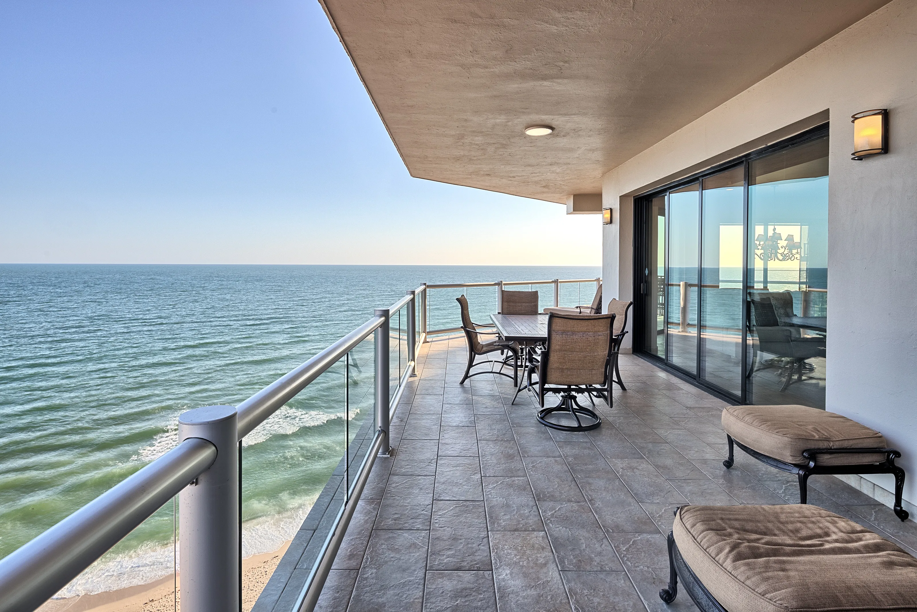Spacious balcony with ocean view and outdoor seating.