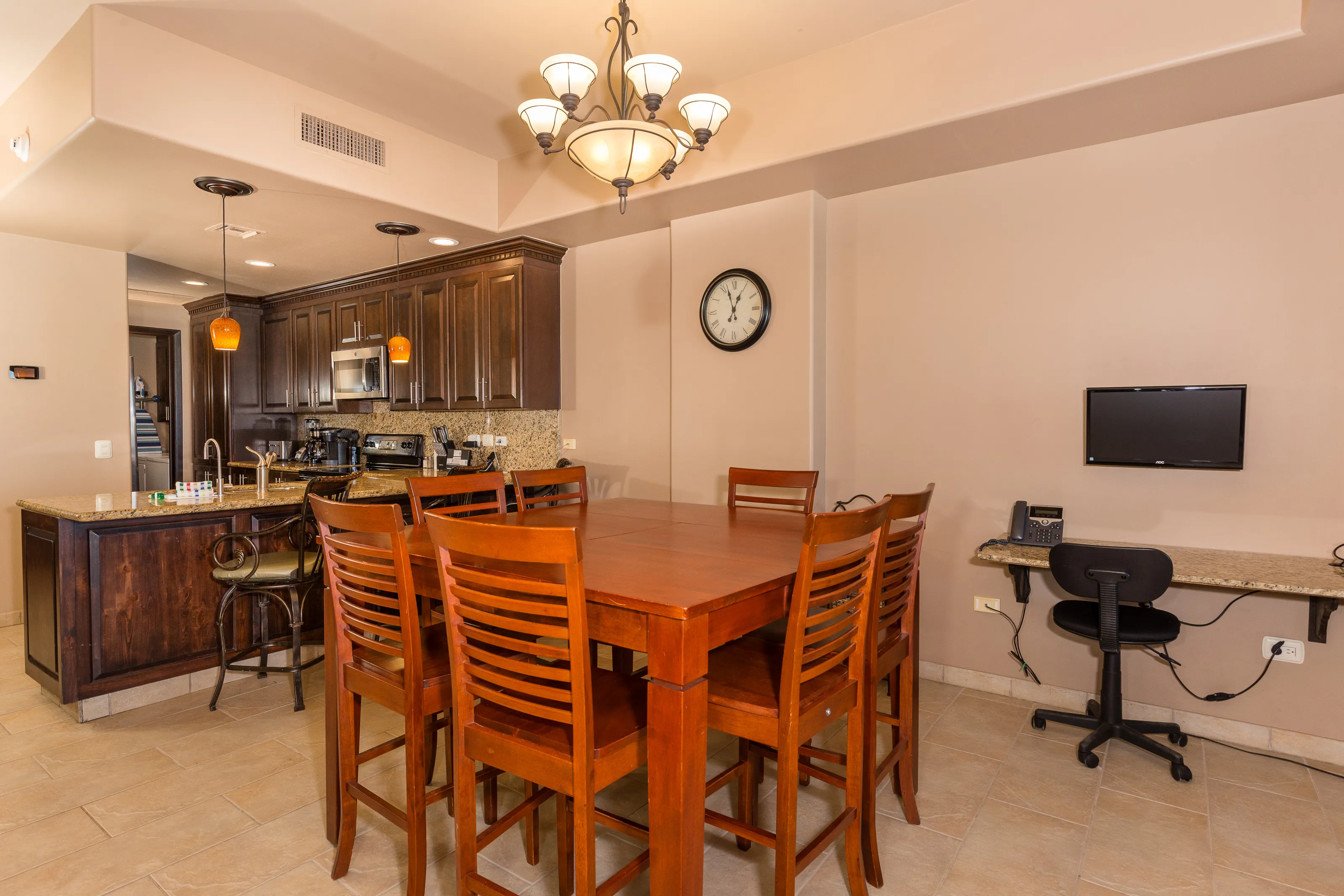 Cozy dining and kitchen area with wooden furniture and warm lighting.