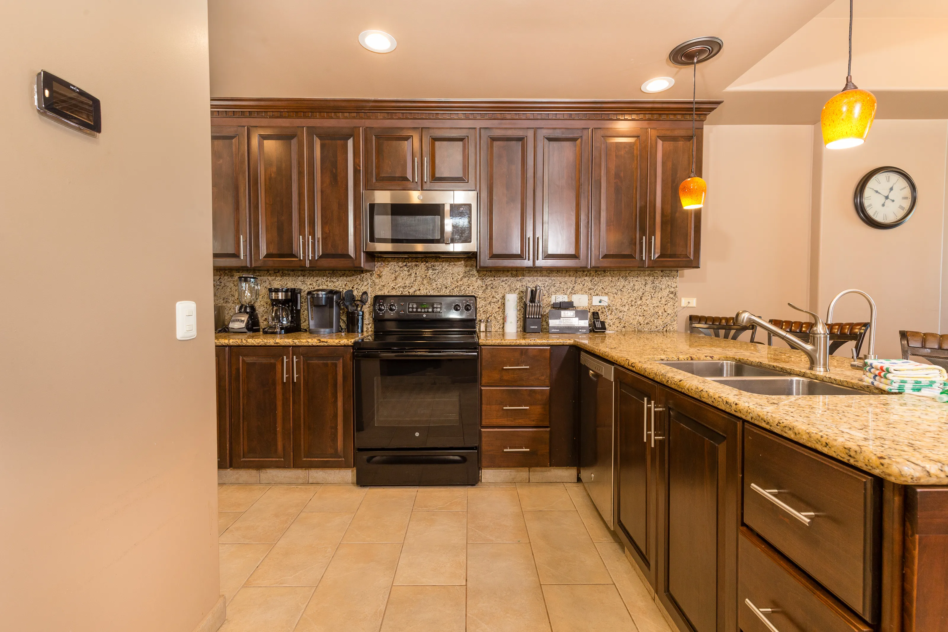 Modern kitchen with wood cabinets and black appliances.