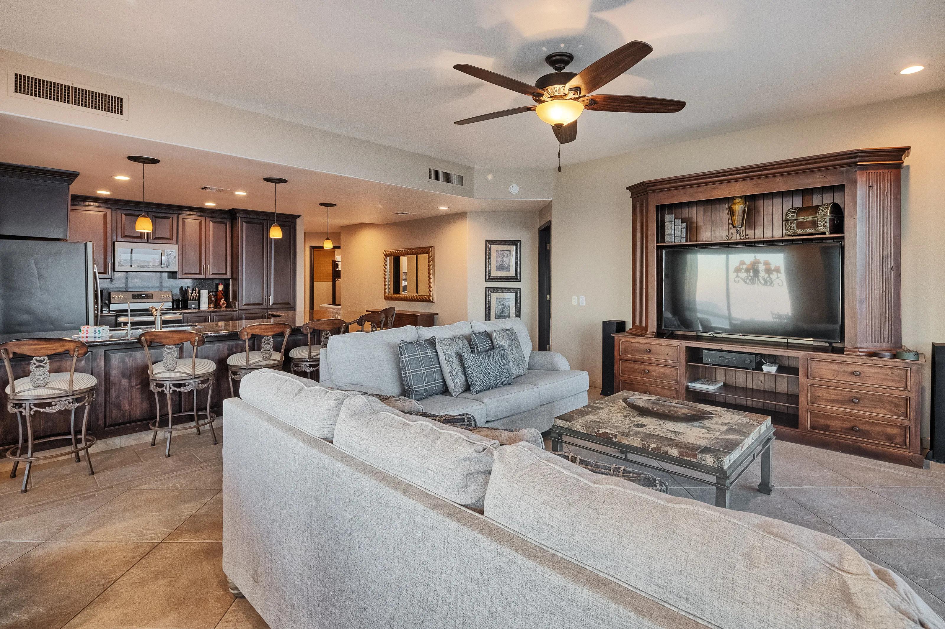 Spacious living room with a large grey sectional sofa and ceiling fan.