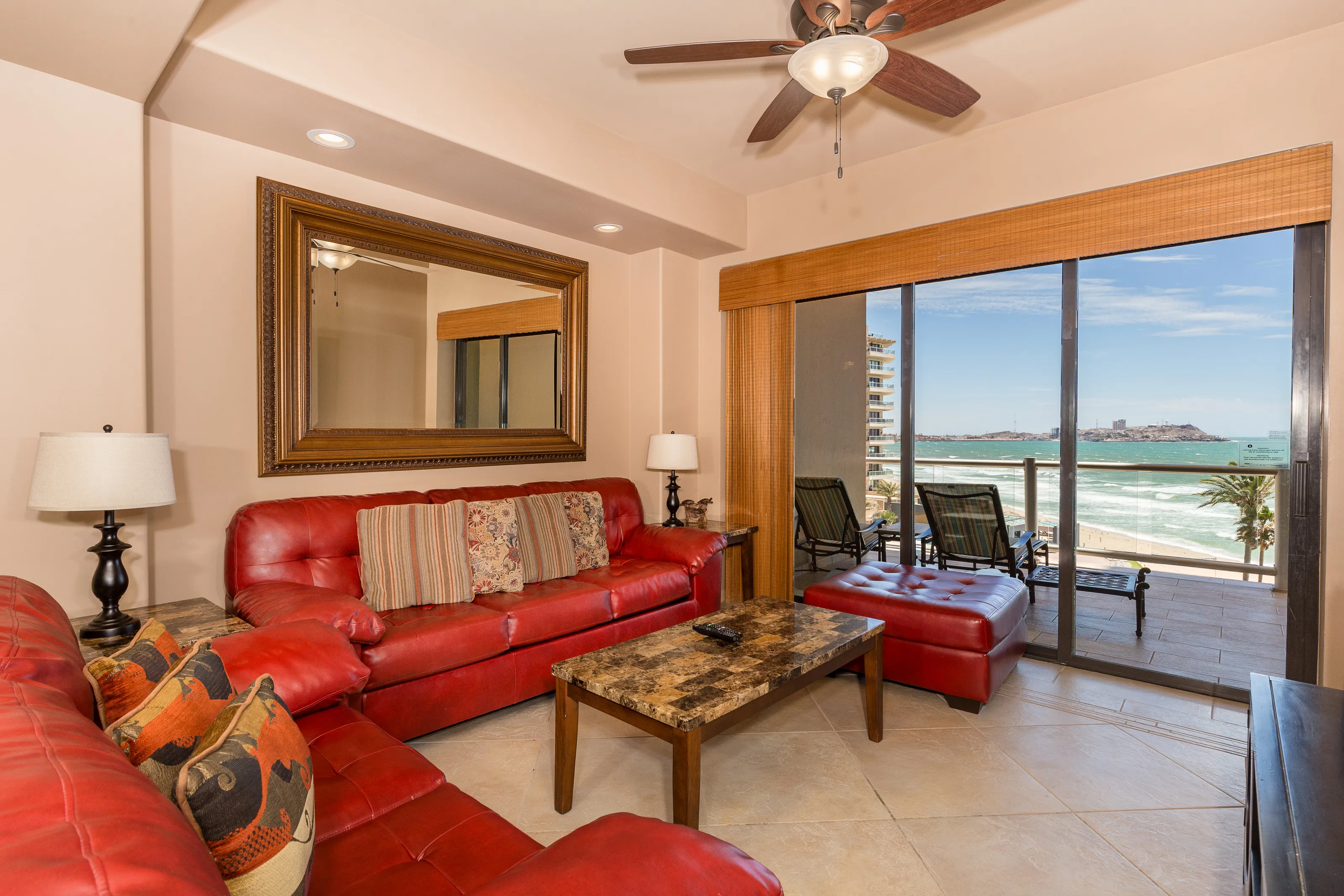 Cozy living room with red sofa and ocean view balcony.