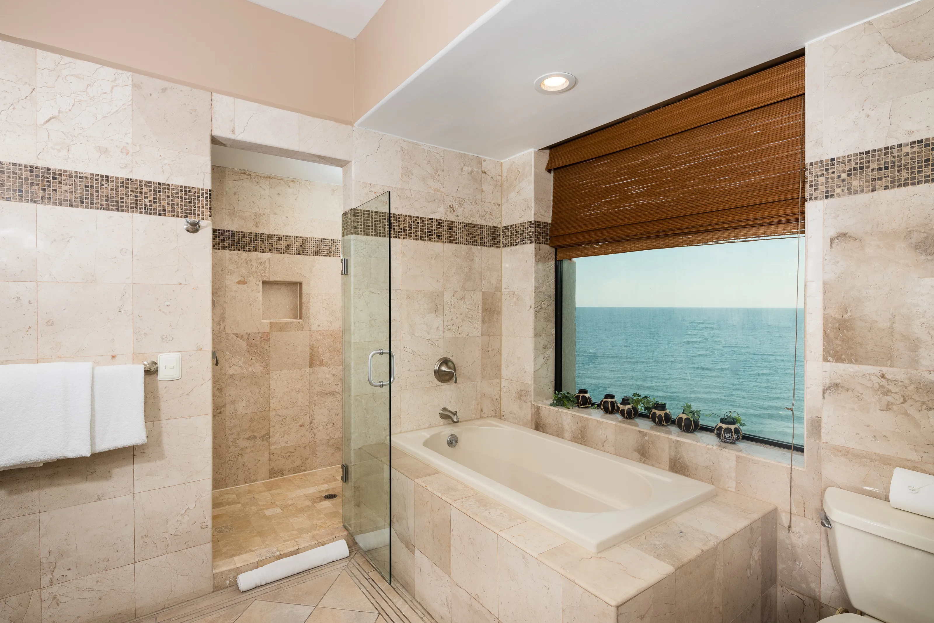 Modern bathroom with a glass shower and ocean view tub.